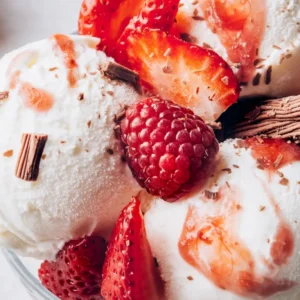 Helado de vainilla con frambuesas y fresas frescas